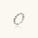 White gold plated ring with architectural lattice design and zirconia accents on cream background