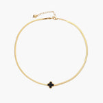 Dainty 18K gold-plated herringbone chain necklace with black enamel quatrefoil clover pendant on white background