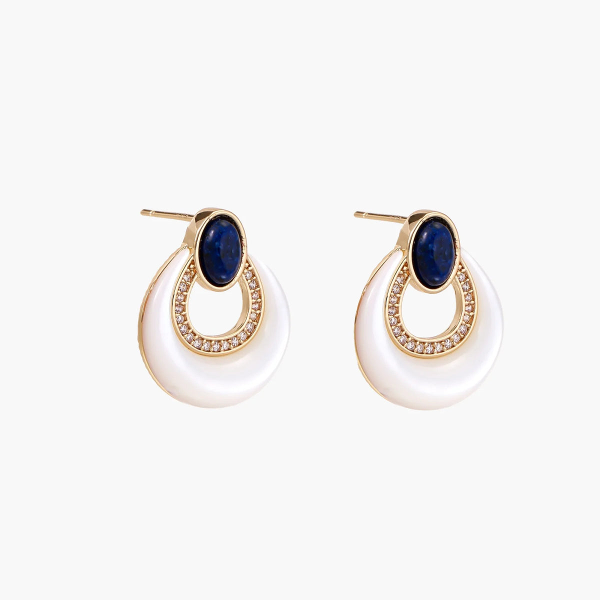 Gold drop earrings with oval lapis lazuli, crystal-paved frame, and iridescent mother-of-pearl teardrop on cream background
