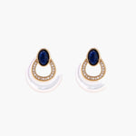 Gold drop earrings with oval lapis lazuli, crystal-paved frame, and iridescent mother-of-pearl teardrop on cream background