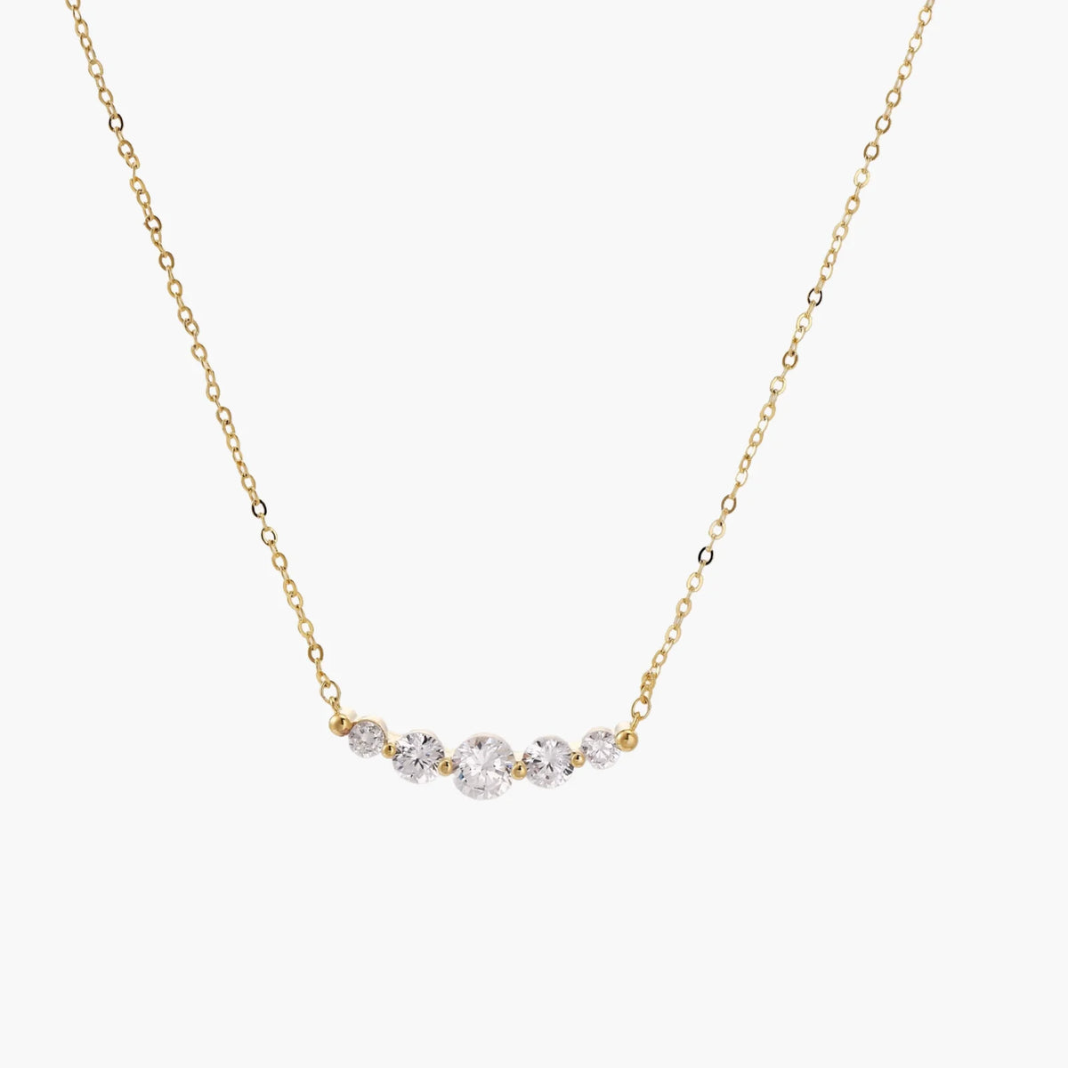 Delicate 14K gold-plated necklace with five graduated zirconia stones arranged in a curved arc on fine chain