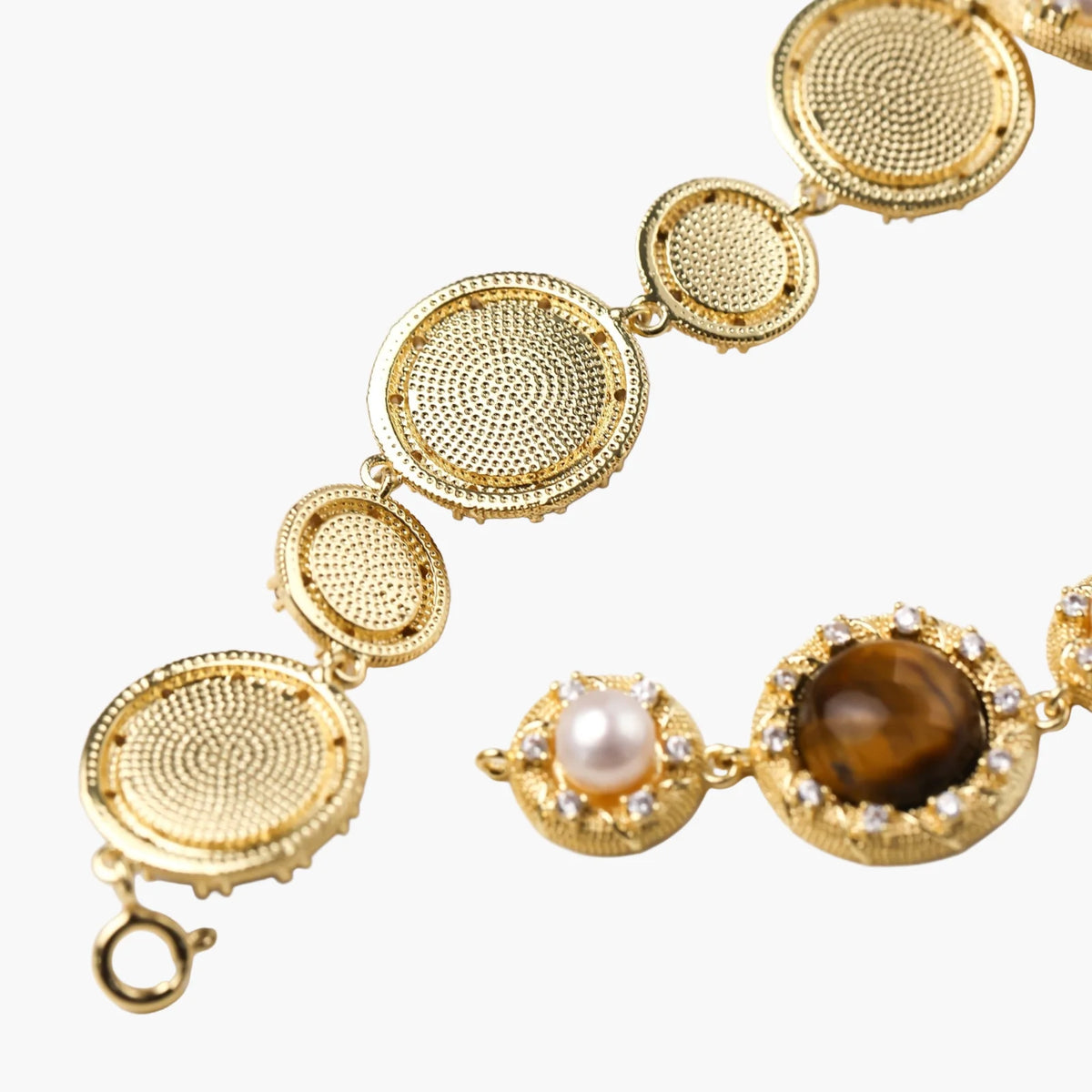 Gold-plated link bracelet with alternating brown tiger's eye stones and white freshwater pearls in ornate bezels.