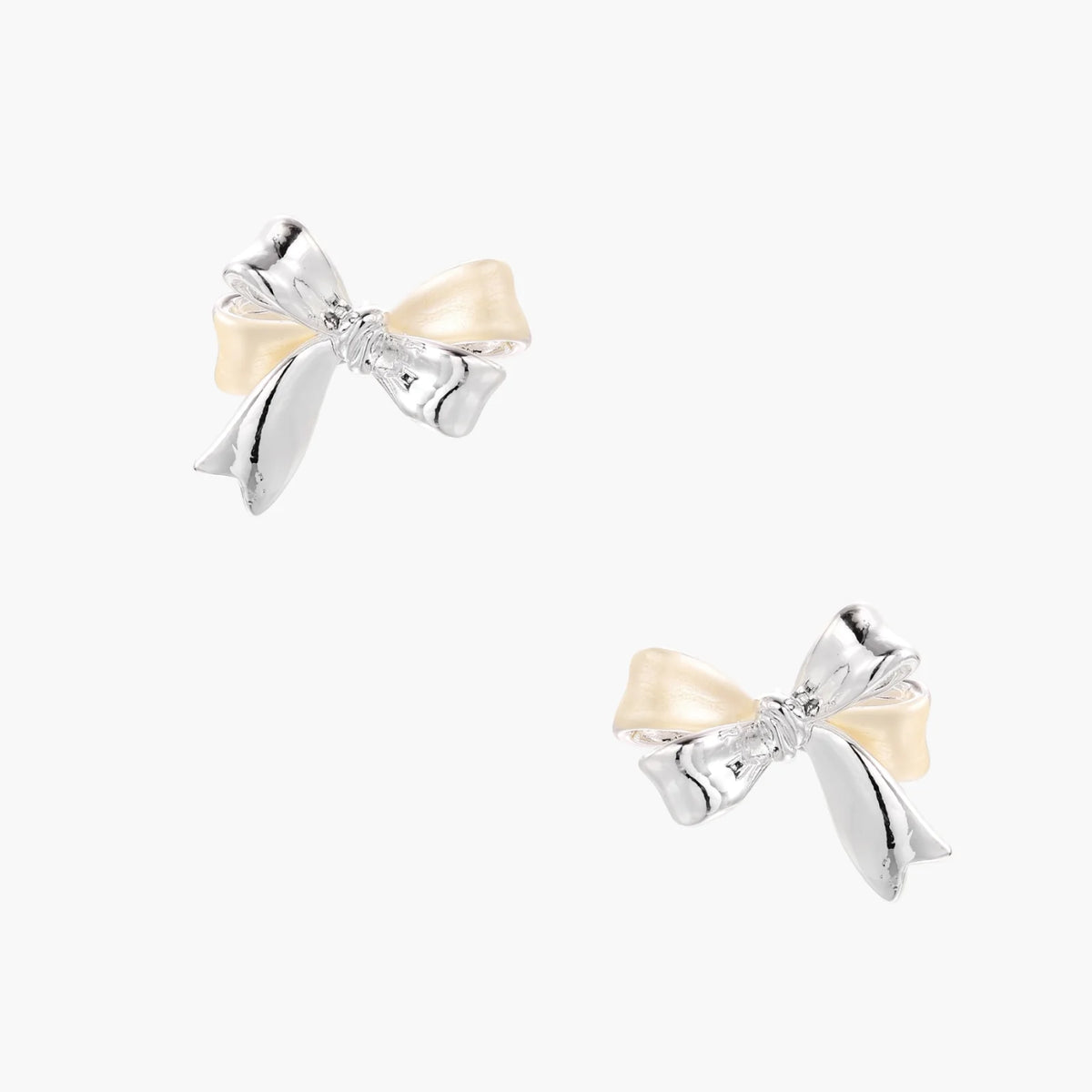Dimensional bow stud earrings in white gold plated brass with silver and cream two-tone finish on neutral background