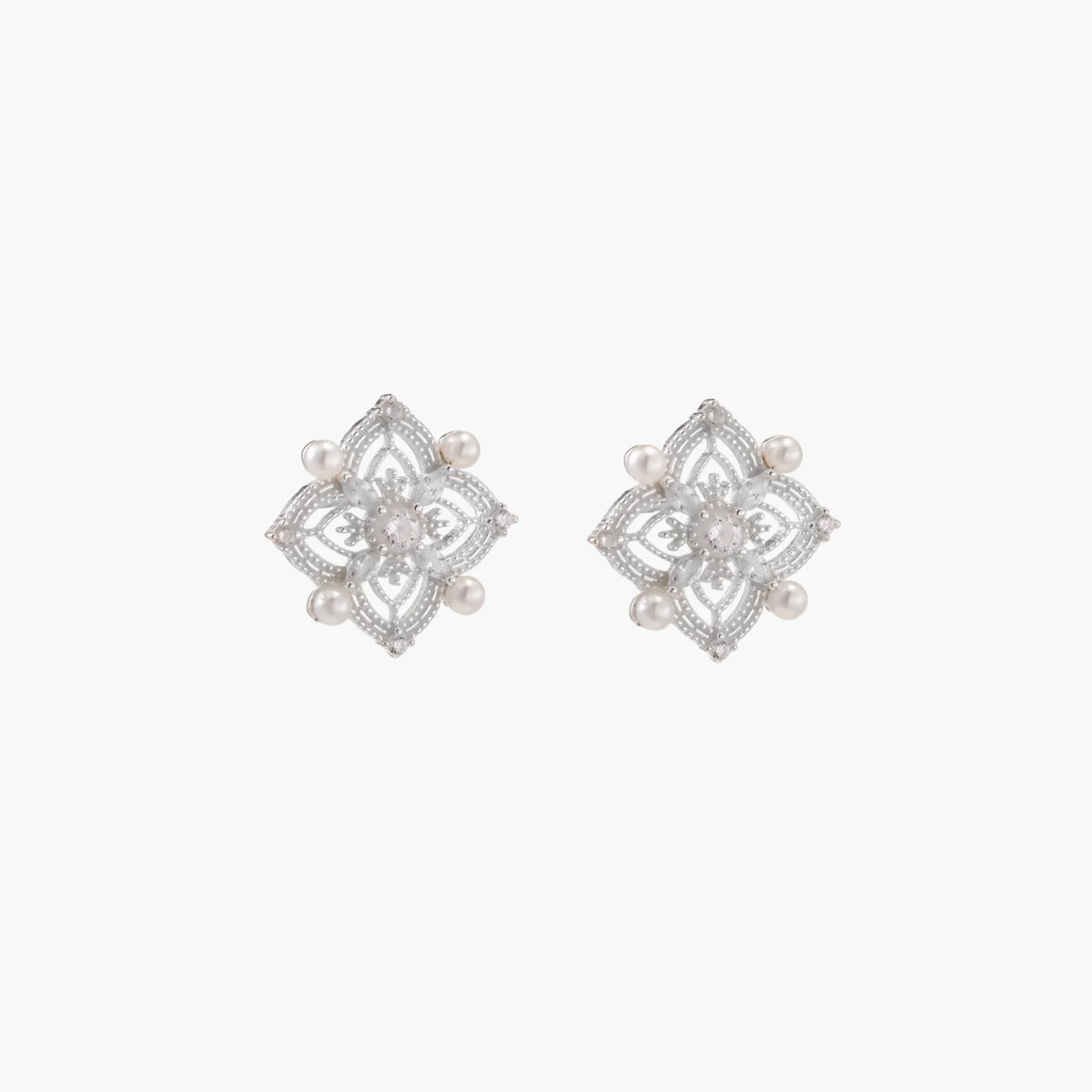Ornate sterling silver stud earrings with mandala-inspired filigree pattern and four freshwater pearls on beige background